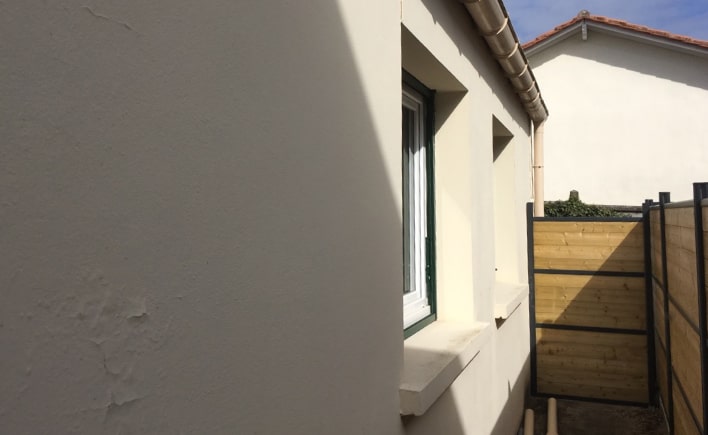 Photo d'une maison avant résine projetée sur le mur